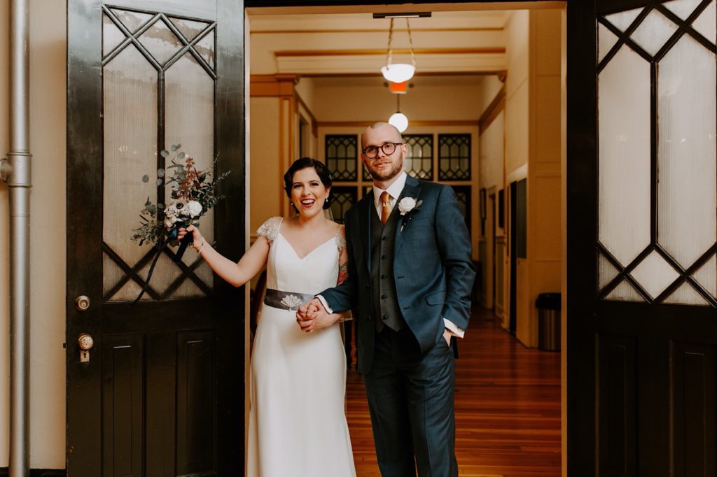 bride and groom entering their reception party at the Asheville  masonic temple