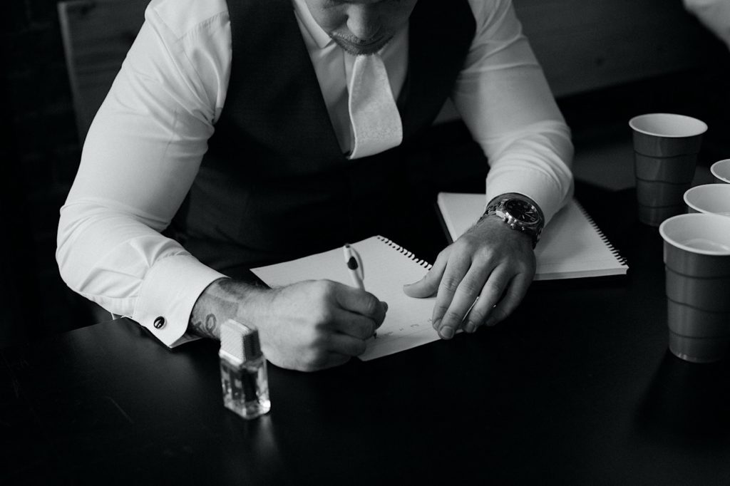 Groom writing his vows on his wedding day