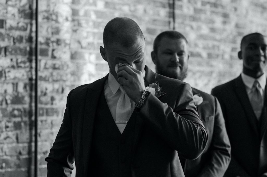 black and white photo of groom crying on wedding day