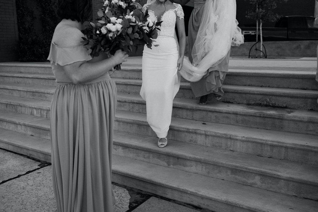 black and white photo of bride walking down stairs