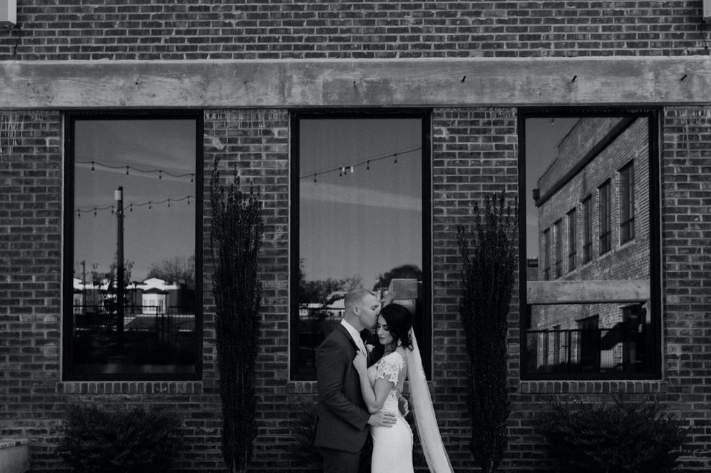 black and white photo of newly web couple at the cadillac service garage in greensboro north carolina