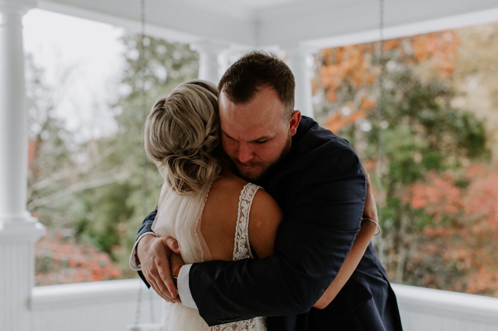 groom embracing his bride at their fall wedding at ritchie hill