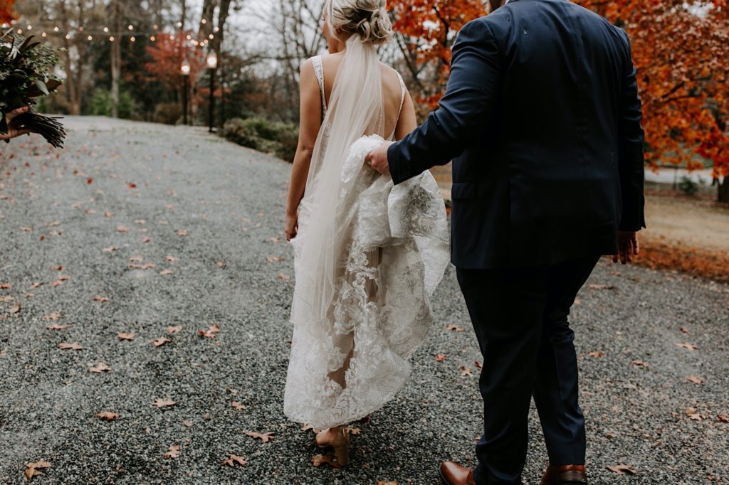 bride and groom walking to their reception during their fall wedding at ritchie hill