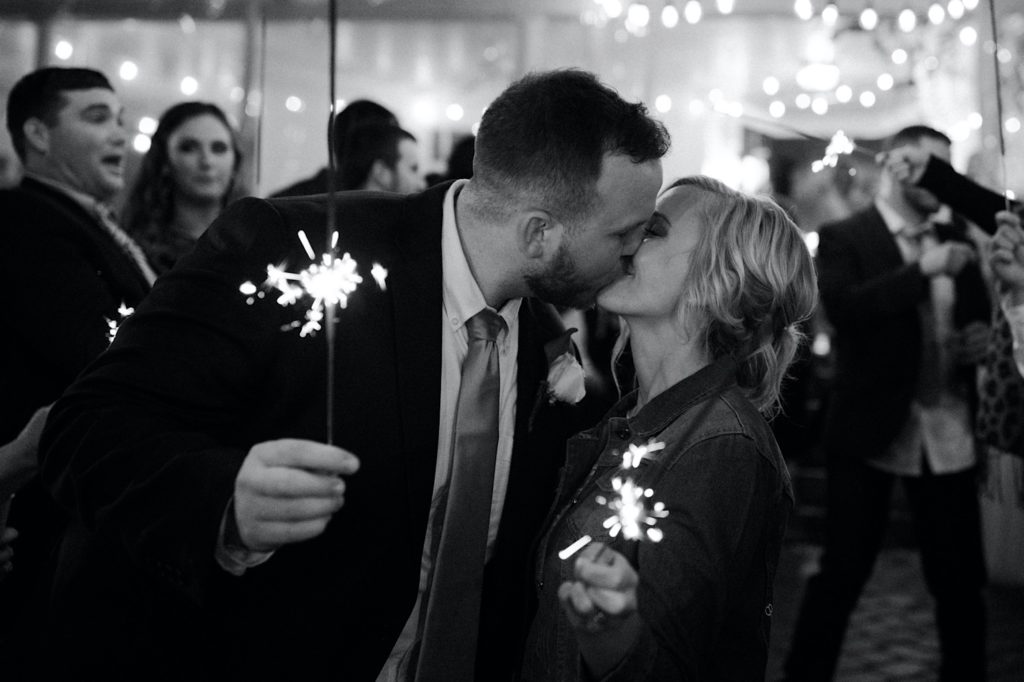 black and white photo of Newlyweds during sparkler exit at ritchie hill in the fall